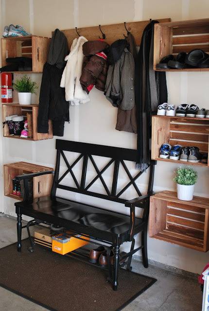 Mudroom featuring a black bench flanked by shelving for shoes and centered under a rack for coats.