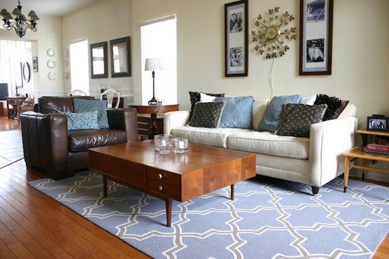 Brown and white sofa set lying in the drawing room with a wooden table and blue rug.