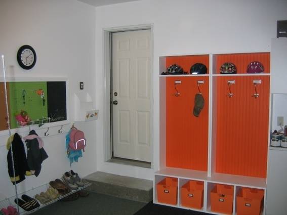 A garage with orange lockers as many items in it.