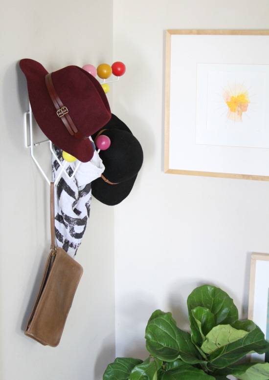 "Hats, wallet and frame is hanging on the wall."