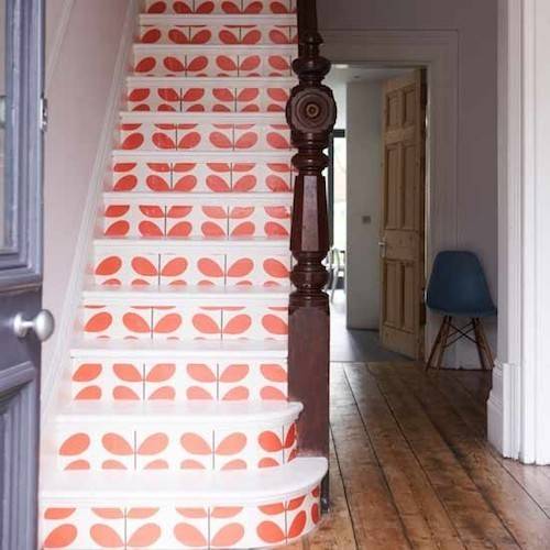 Entryway to the stairs, the stairs have a colorful type of wallpaper with orange leaves.