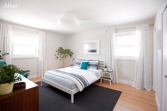 A white bedroom has blue accent pieces.