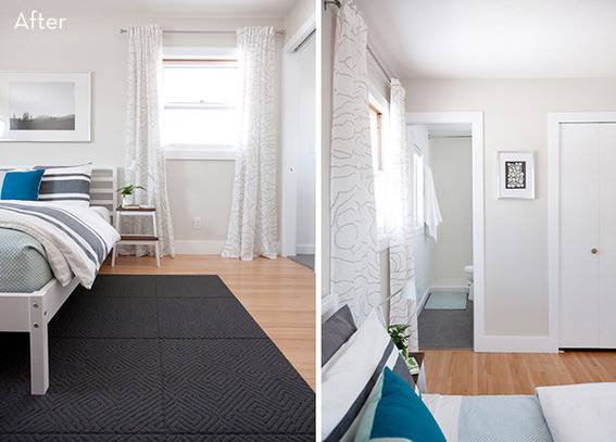 A bed sits on a dark rug in a white bedroom.