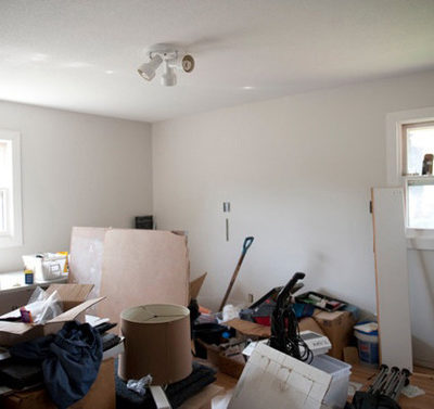 A living room is cluttered and messy.