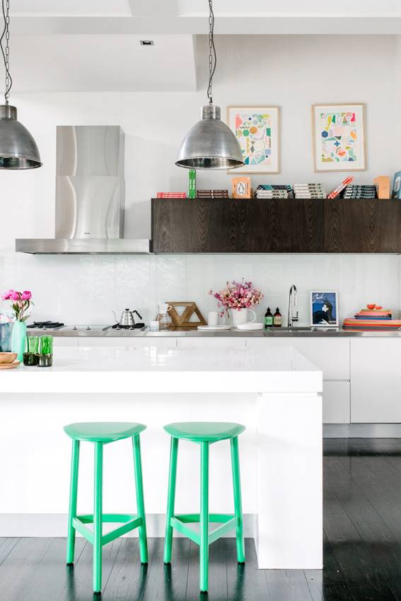 Open concept white kitchen, with green bar stools.