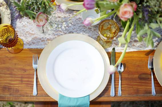 A plate and utensils are set up on a piece of wood.
