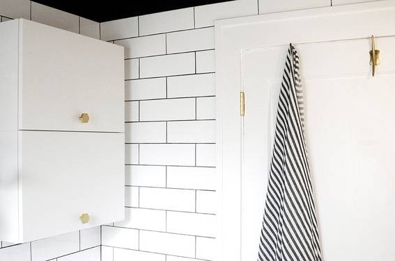 "Dramatic bathroom with cupboards and black and white towel."