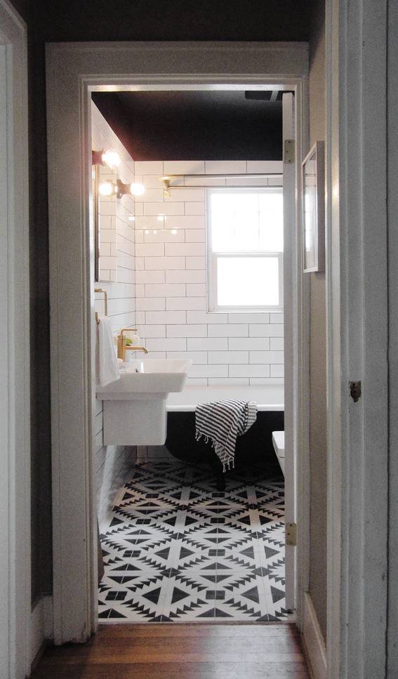 " A Dark and dramatic bathroom with black and white tiles."