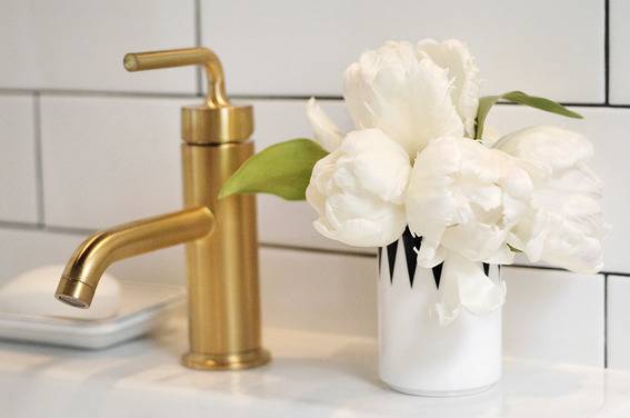 A gold Faucet and white roses