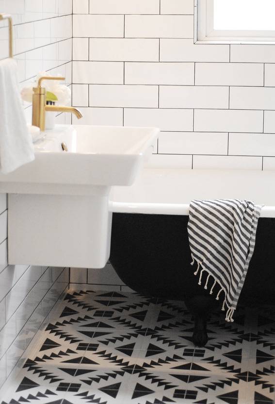 A bathroom in black and white with patterned tiles.