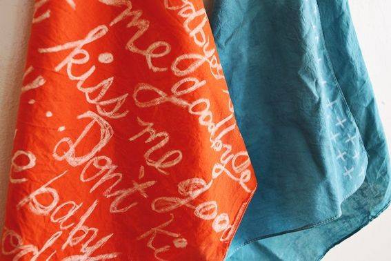 An orange cloth hangs next to a blue cloth.
