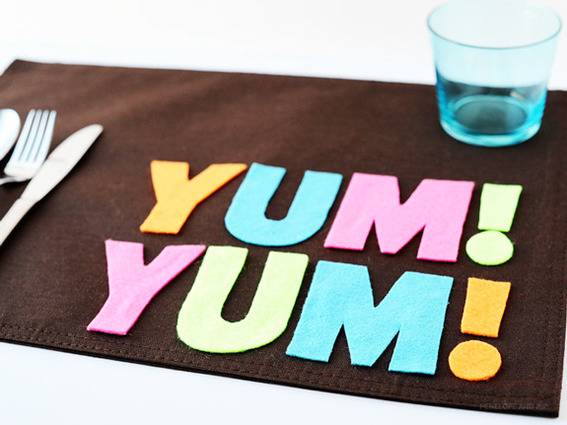 The words Yum Yum are spelled out on a brown place mat.