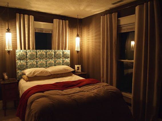 A dimly lit bedroom has earth tones.