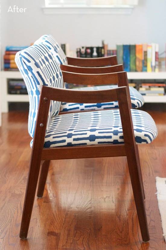 A Blue and white chair has wooden arms and legs on a wooden floor.