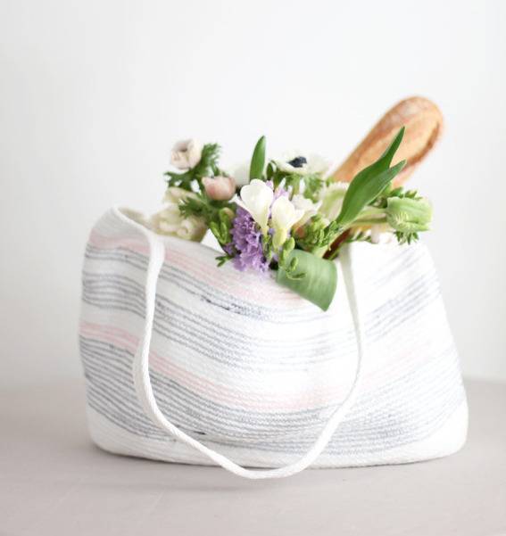 A striped tote bag holds flowers.