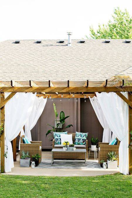 Curtains shield off the wind in an outdoor sitting area.