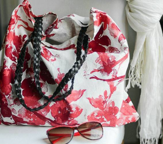 A tote bag with a red flower pattern added.