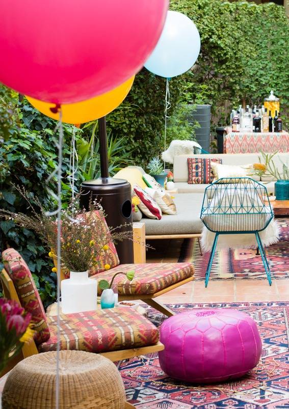 An outdoor patio with a variety of seating, decorated for a party.