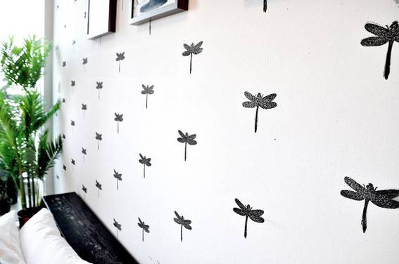 Black and white dragon fly wallpaper in a bedroom.