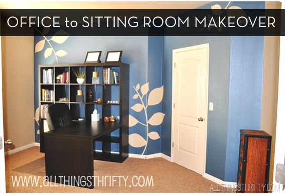 A room with blue walls that has a leaf pattern on it in a room with a black desk.