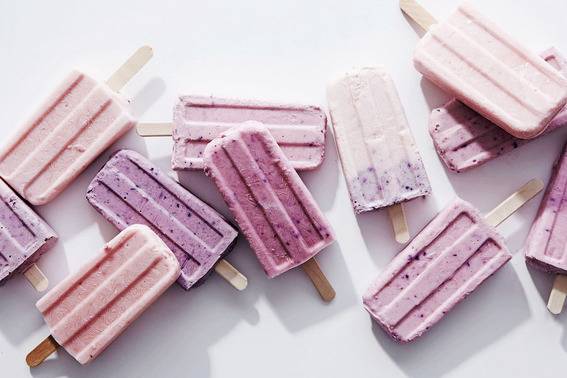 "Colorful stick ice creams are on the white surface."