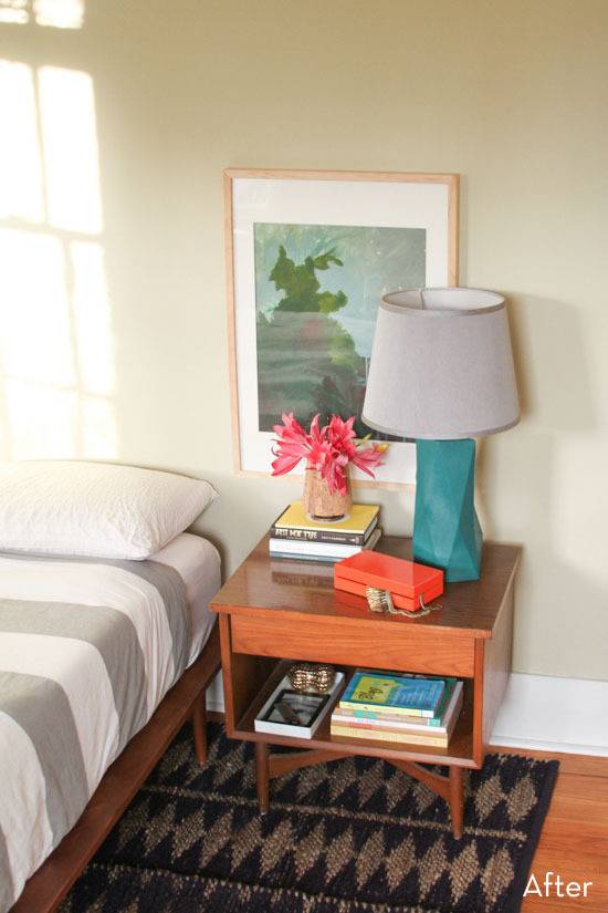 "Bedroom with nightstand,wall hangings and books."