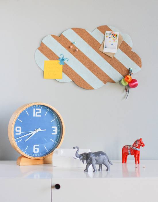 A white desk has animals, a clock and a picture above.