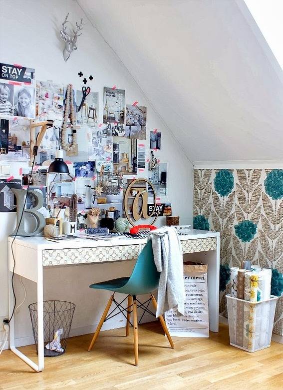 An office workspace with lots of inspiration pictures on the wall.