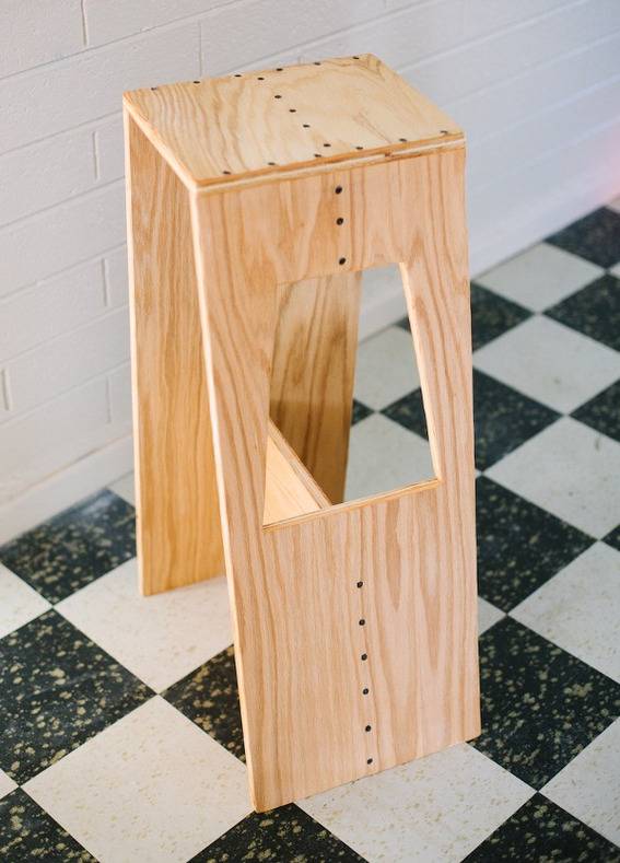 "Stylish stool with hole in flat checked surface."