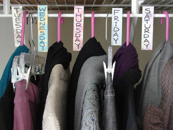 Hanging clothes separated by day tags.