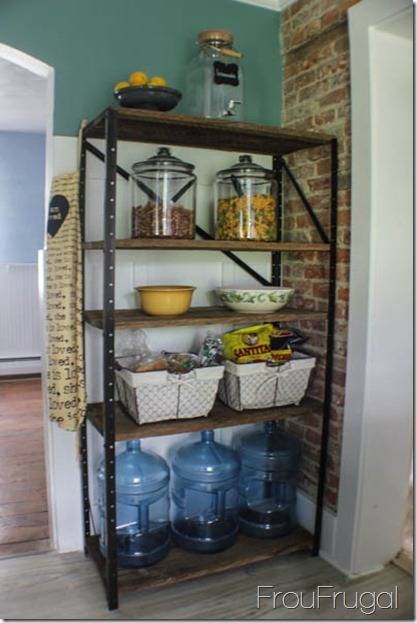 A reck situated in the corner holding glass containers, water bottles and baskets.