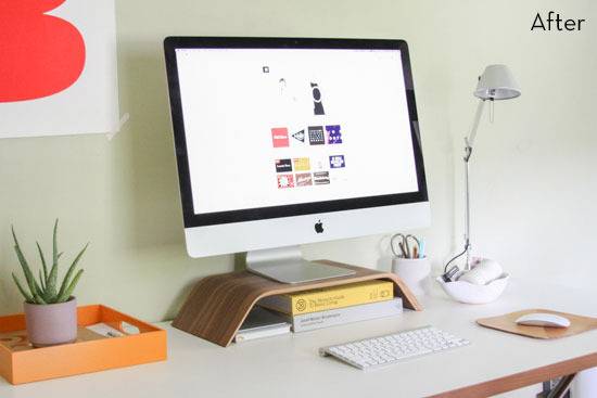 An iMac sits atop a computer desk with decor, ornaments and a lamp.