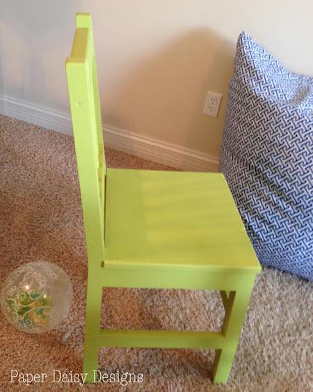 A light green chair sits on the carpet.