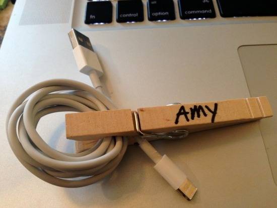 A clothes pin with the name Amy on it is clipped around a usb cable.