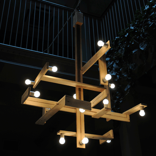 An industrial, geometric wooden lamp has mini bulbs.