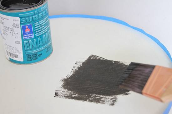 Black enamel being painted on a white surface.
