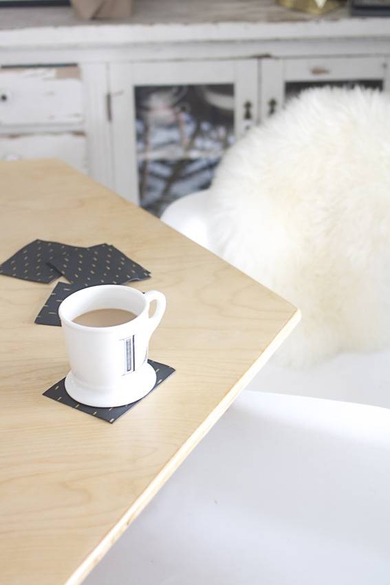 A filled mug sitting on a cupholder on top of a table.