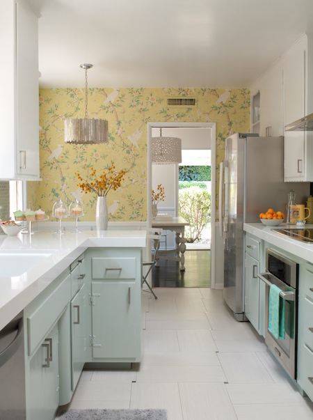A kitchen has white tiles and light blue cabinets.