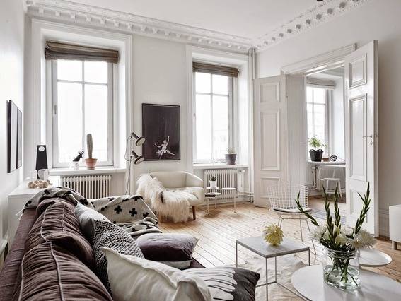A living room has white walls and a large sofa.