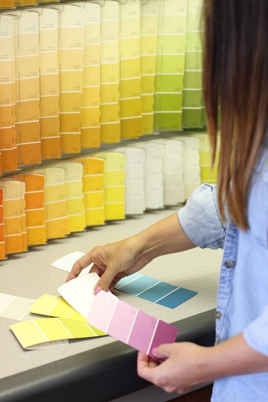 A woman looks at different color strips.