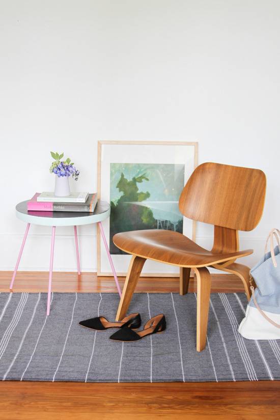 Reading area with a small modern wood chair, some shoes, and a side table.