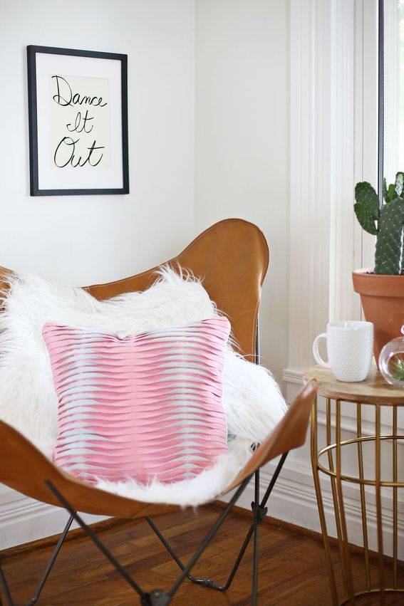 Large brown chair with a huge pink pillow in the seat.