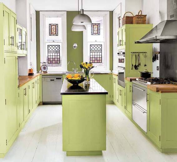 An olive green kitchen with a bowl of lemons on the island.
