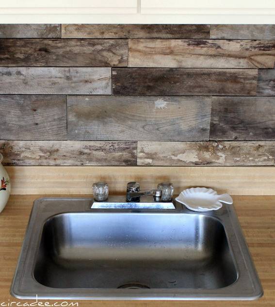 A clean sliver sink has a small white fish plate sitting by the faucet with a faux wood backslash.