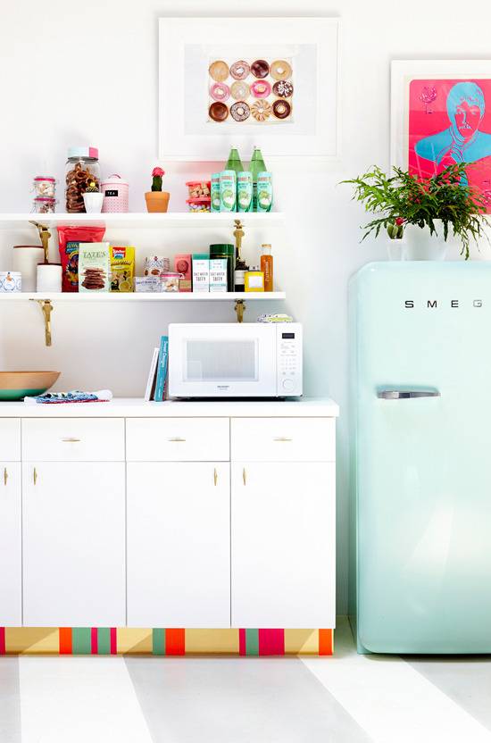 A kitchen has white cabinets and a light teal refrigerator.