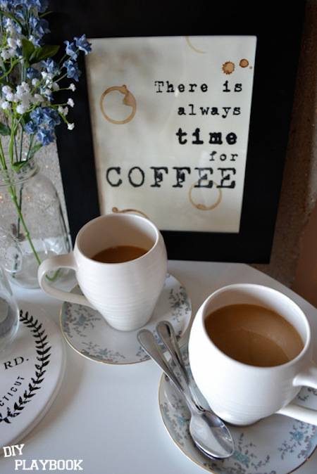 A Cute coffee sign sits on a pretty table setting with small glasses of cappuccino colored coffee.