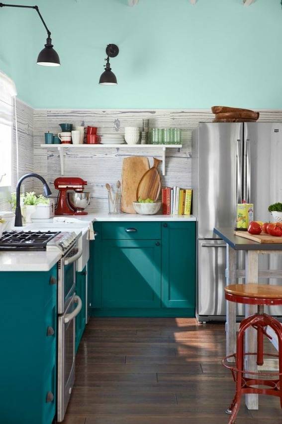 A kitchen is decorated with light blue and teal cabinets.