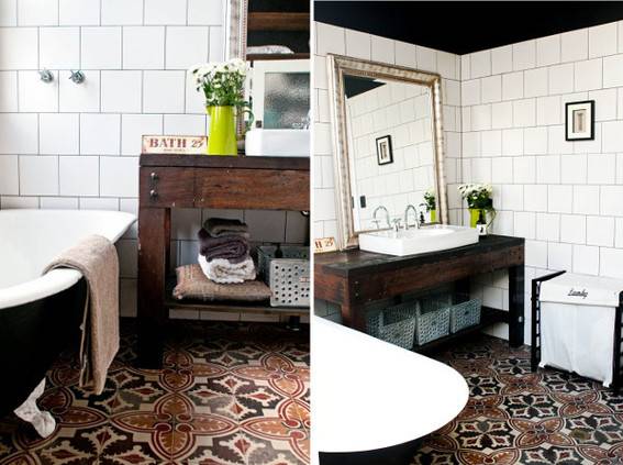 A brown claw bathtub next to a brown table with a brown design rug and a brown side table with an insert white sink against a large rectangular mirror.