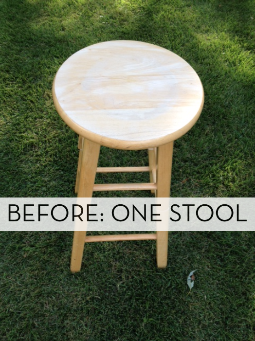 One raw wood stool with a round seat on a lush green lawn.