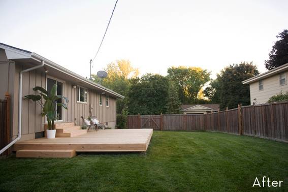A light brown house has a fenced in backyard.